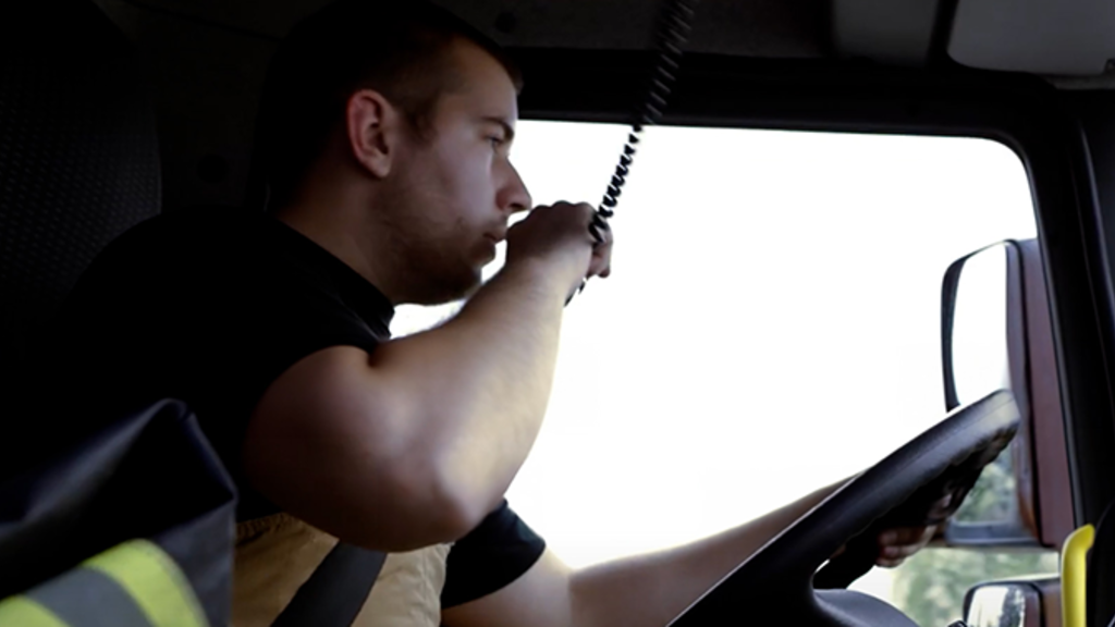 EMS driver on the radio in an ambulance cab.
